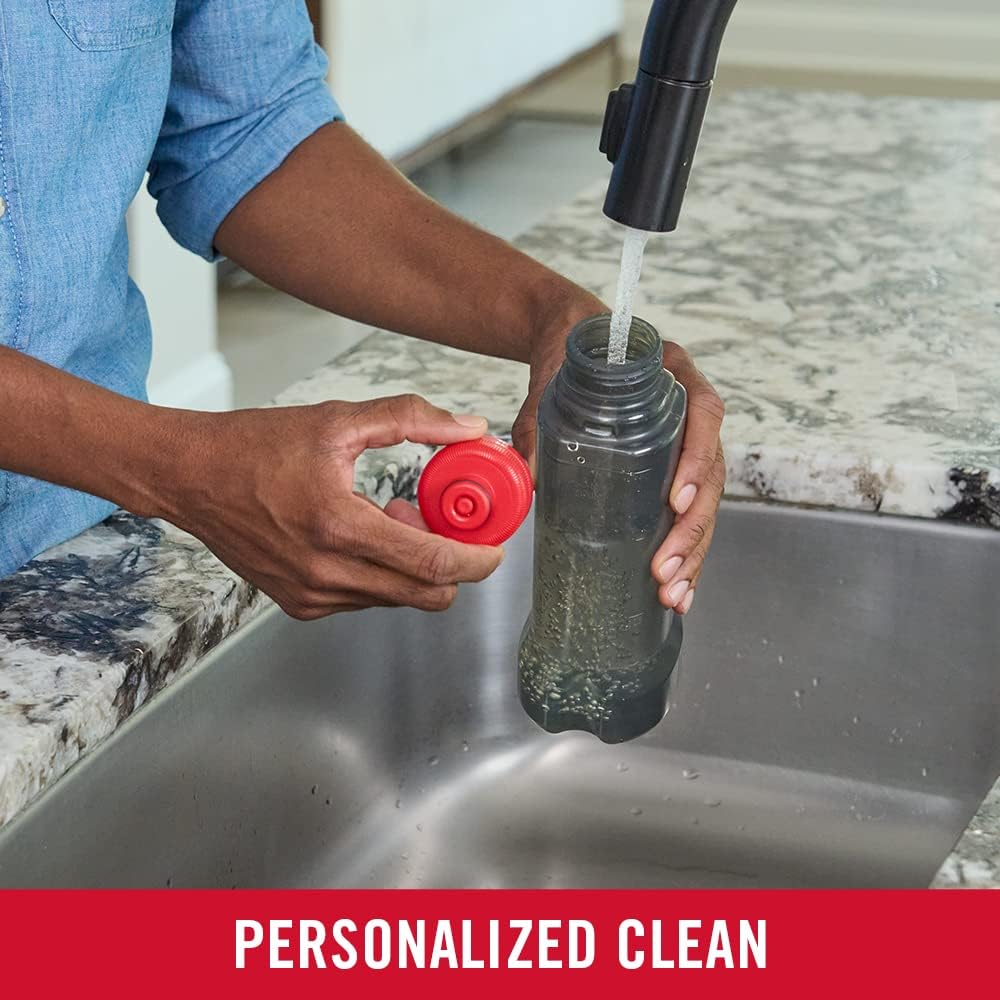 Rubbermaid Reveal refillable spray mop bottle being filled at a sink