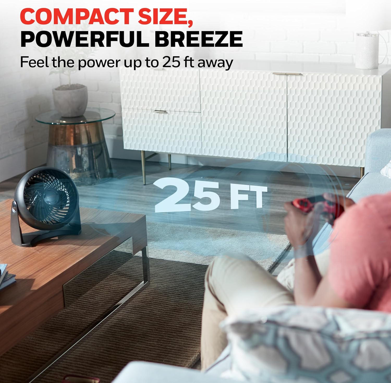 Black Honeywell HT-900 in a living-room setting with the manufacturer 25-foot airflow claim shown.