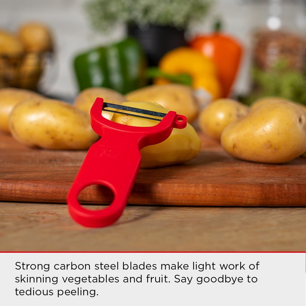 Red Kuhn Rikon Original Swiss Peeler beside potatoes and vegetables