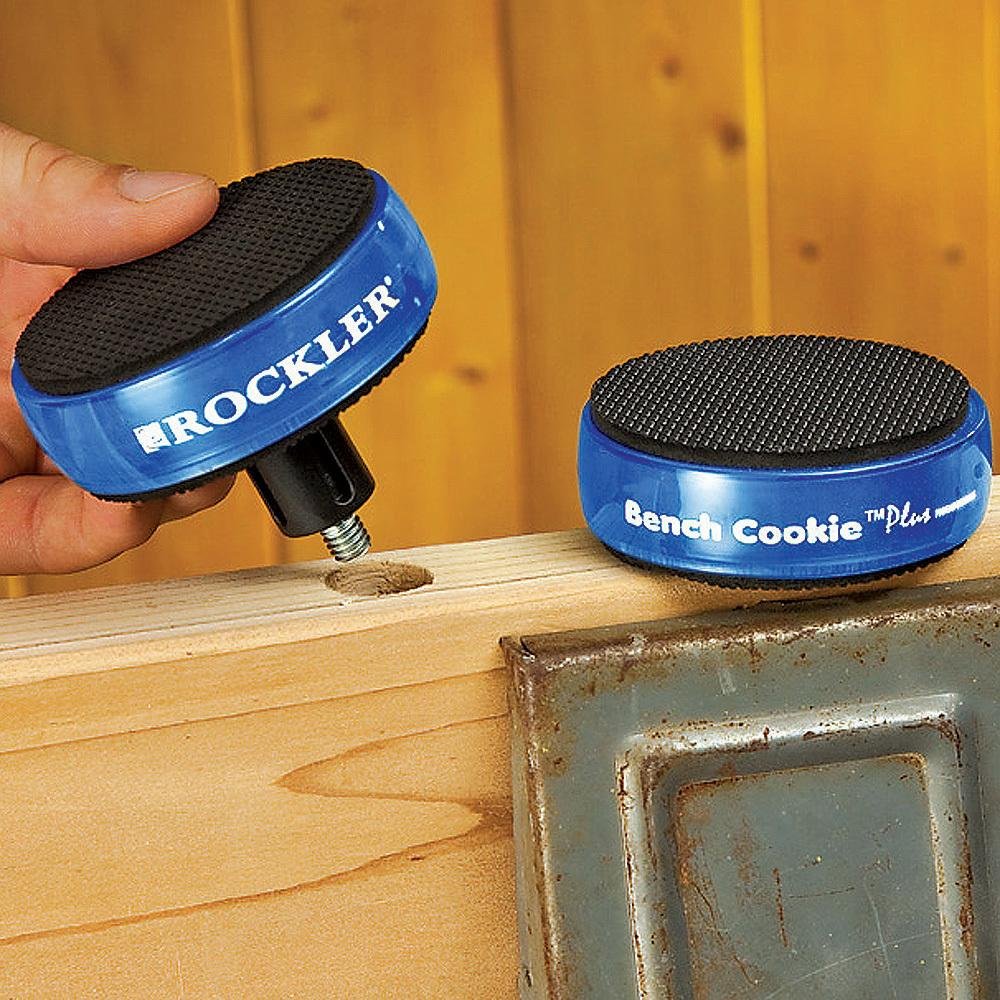 Two blue Rockler Bench Cookie Plus supports on a workshop beam, one lifted to show its threaded riser connection