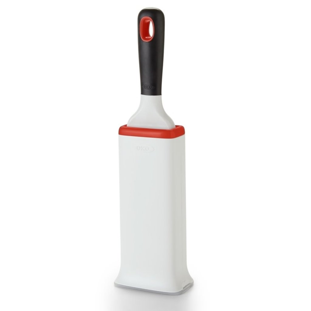 OXO FurLifter Garment Brush inserted into its white and red self-cleaning base.