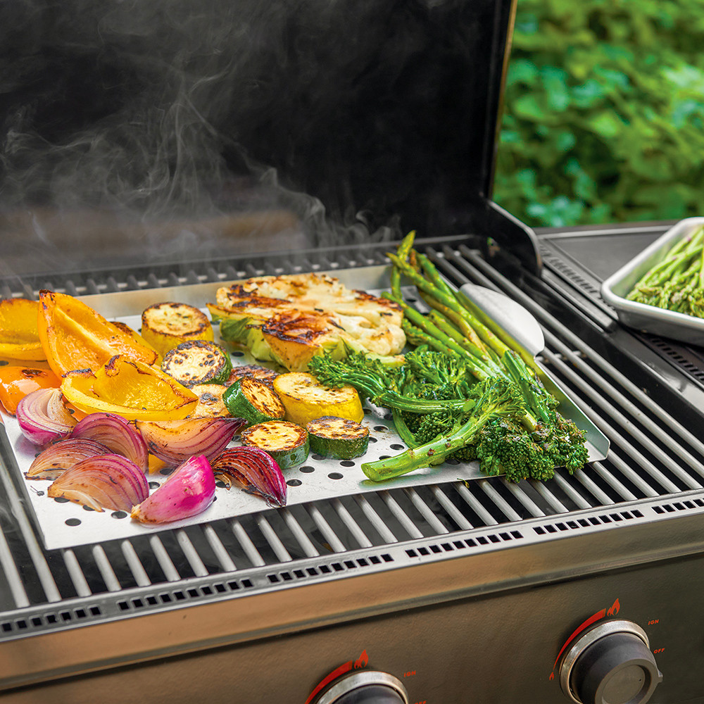 Nordic Ware 36520 perforated grill topper holding assorted vegetables on a grill
