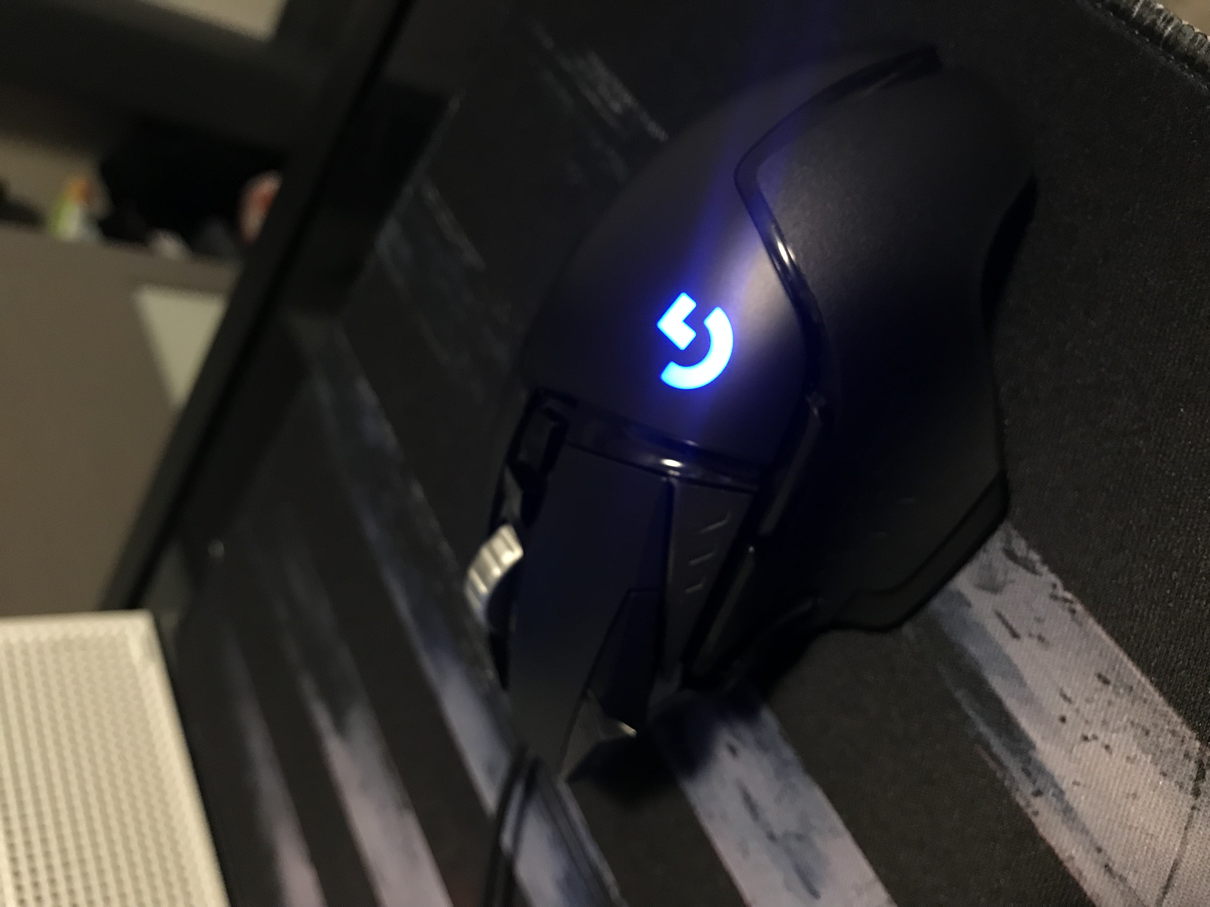 Angled view of a black wired Logitech G502 HERO, with the metal wheel and top controls visible.