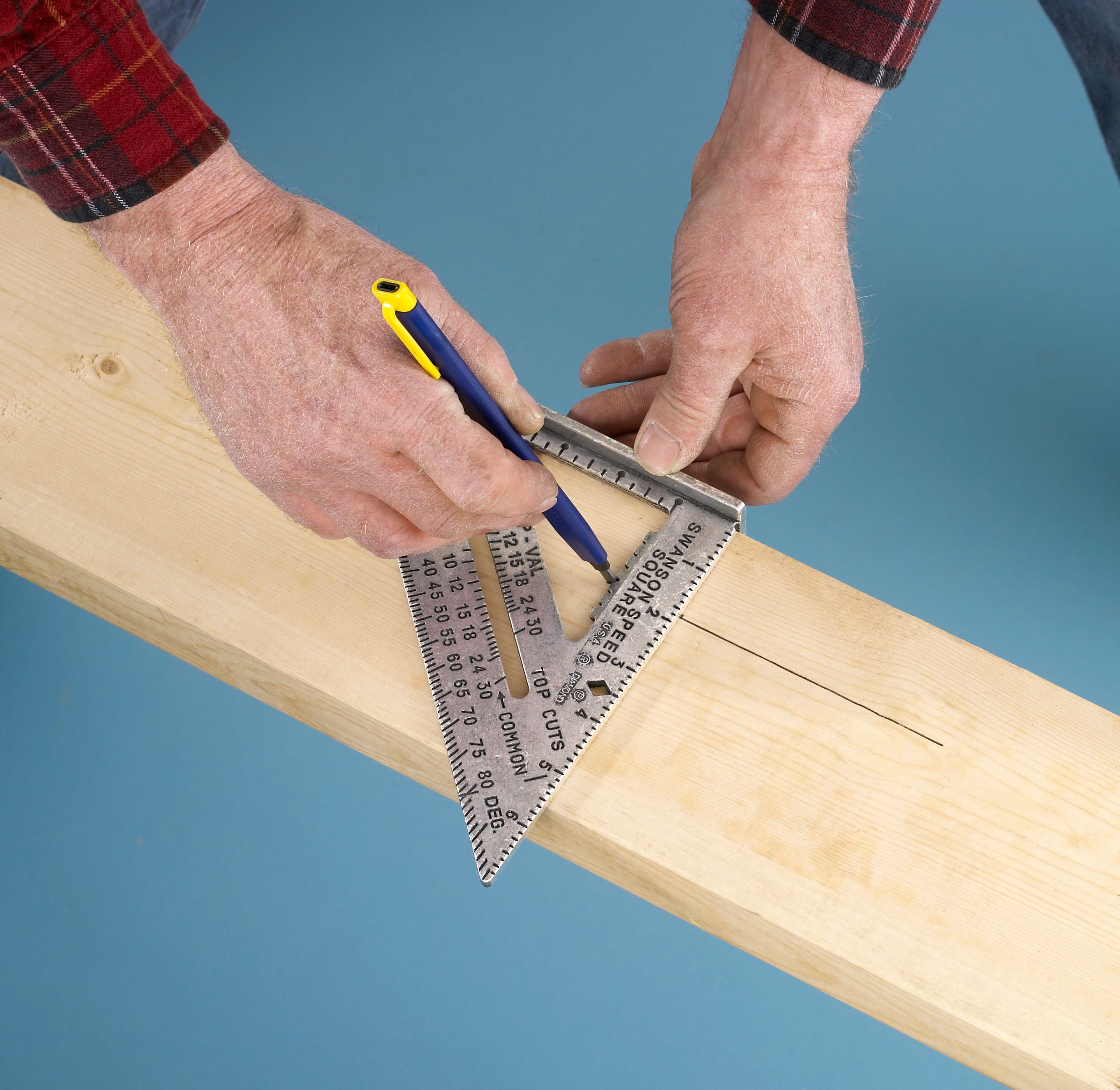 Swanson S0101 Speed Square held against a board while a pencil marks through a scribing notch