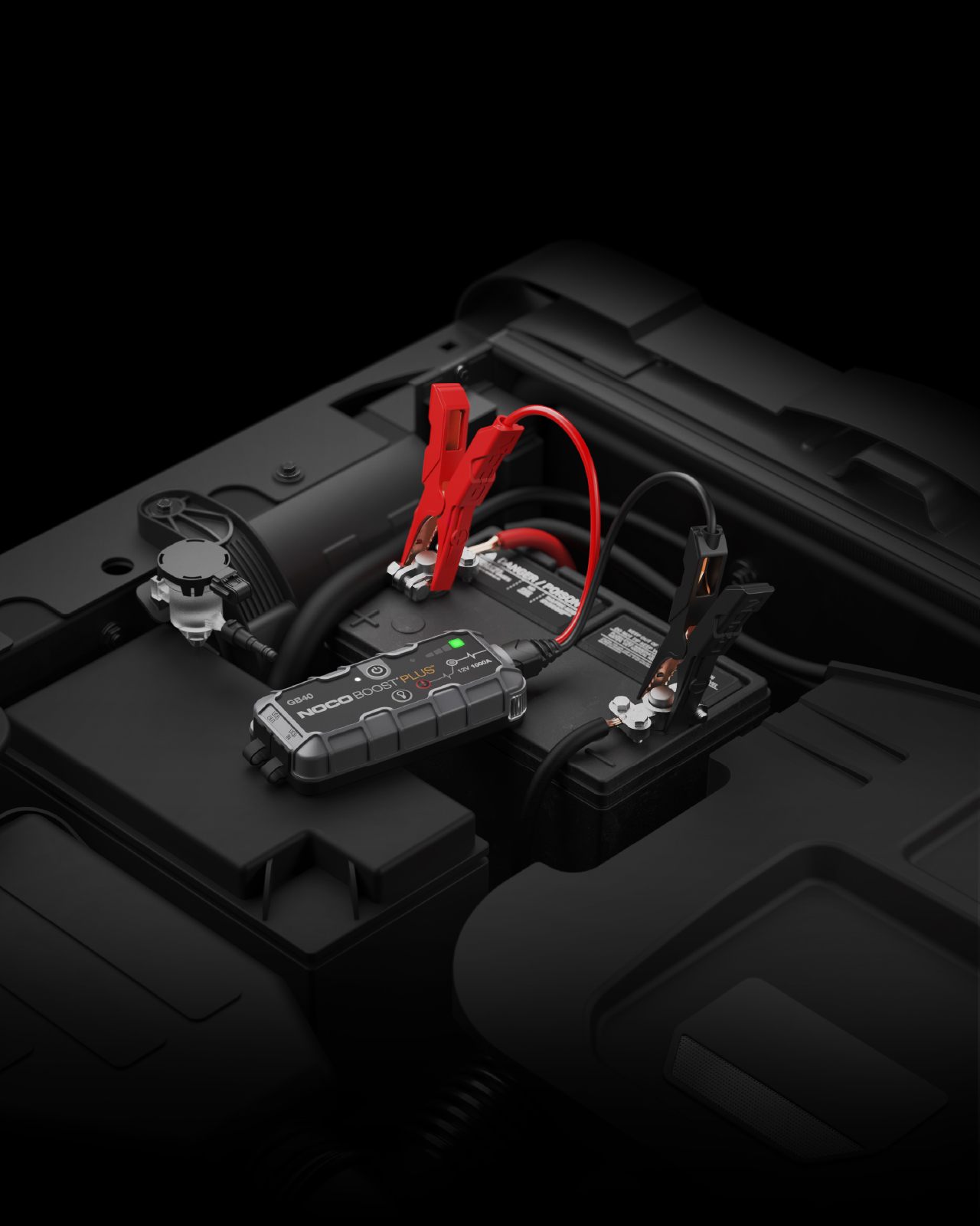 NOCO Boost Plus GB40 connected to a 12V vehicle battery in an engine bay