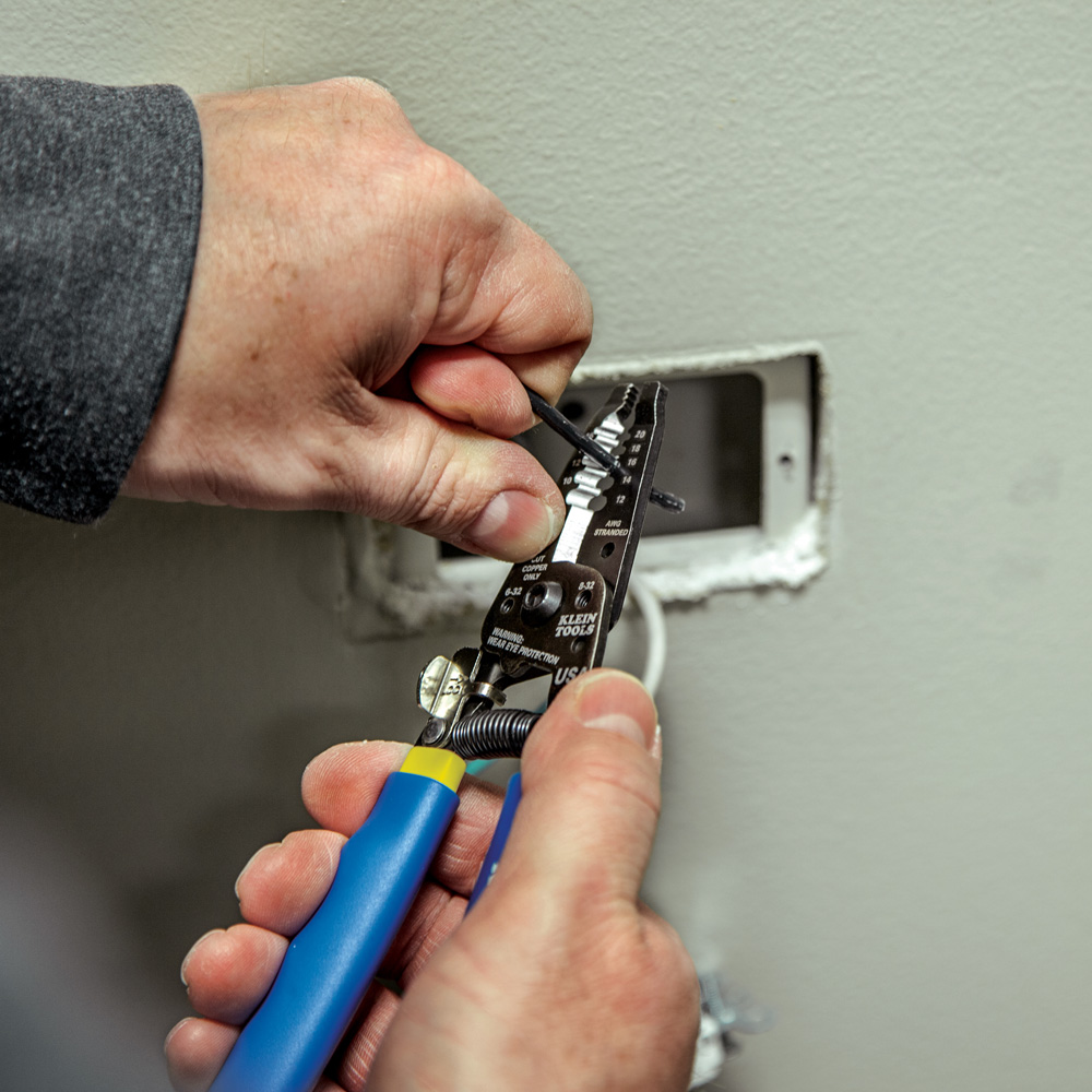 Klein Tools 11055 stripping a wire near an electrical box