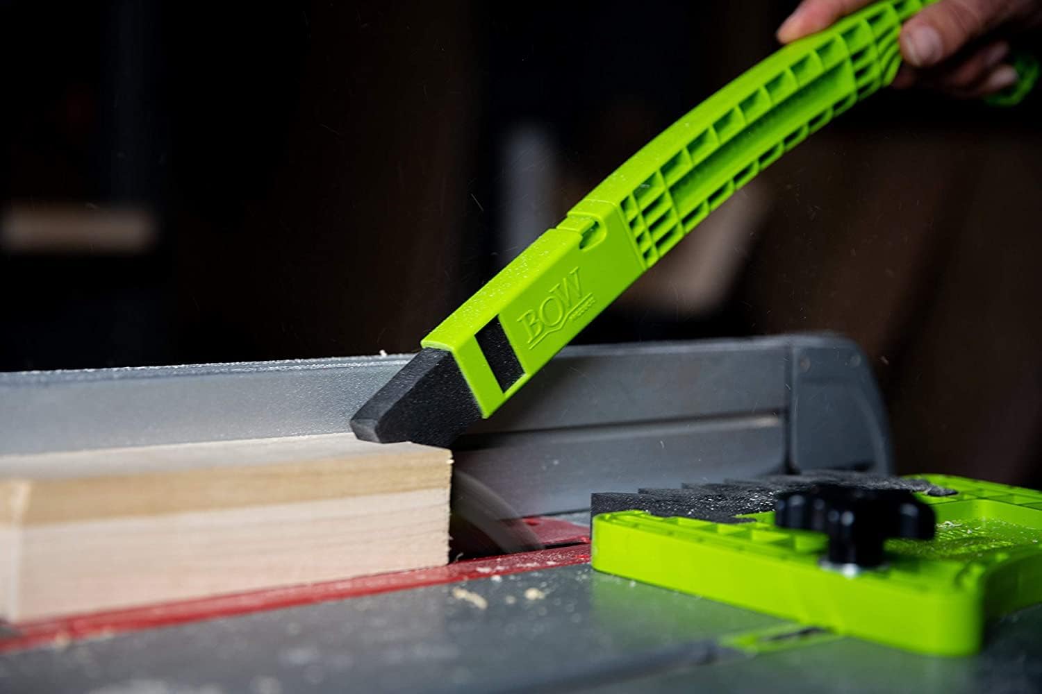 Full-size green BOW PushPRO PP1 with its black EVA tip contacting a wood workpiece; another feed accessory is visible.