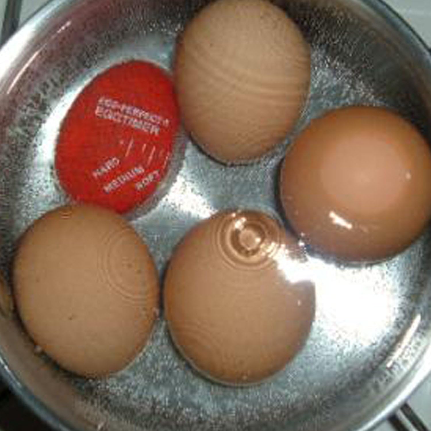 Norpro 5902C Egg Perfect 熟度计与四颗鸡蛋一起在锅中加热