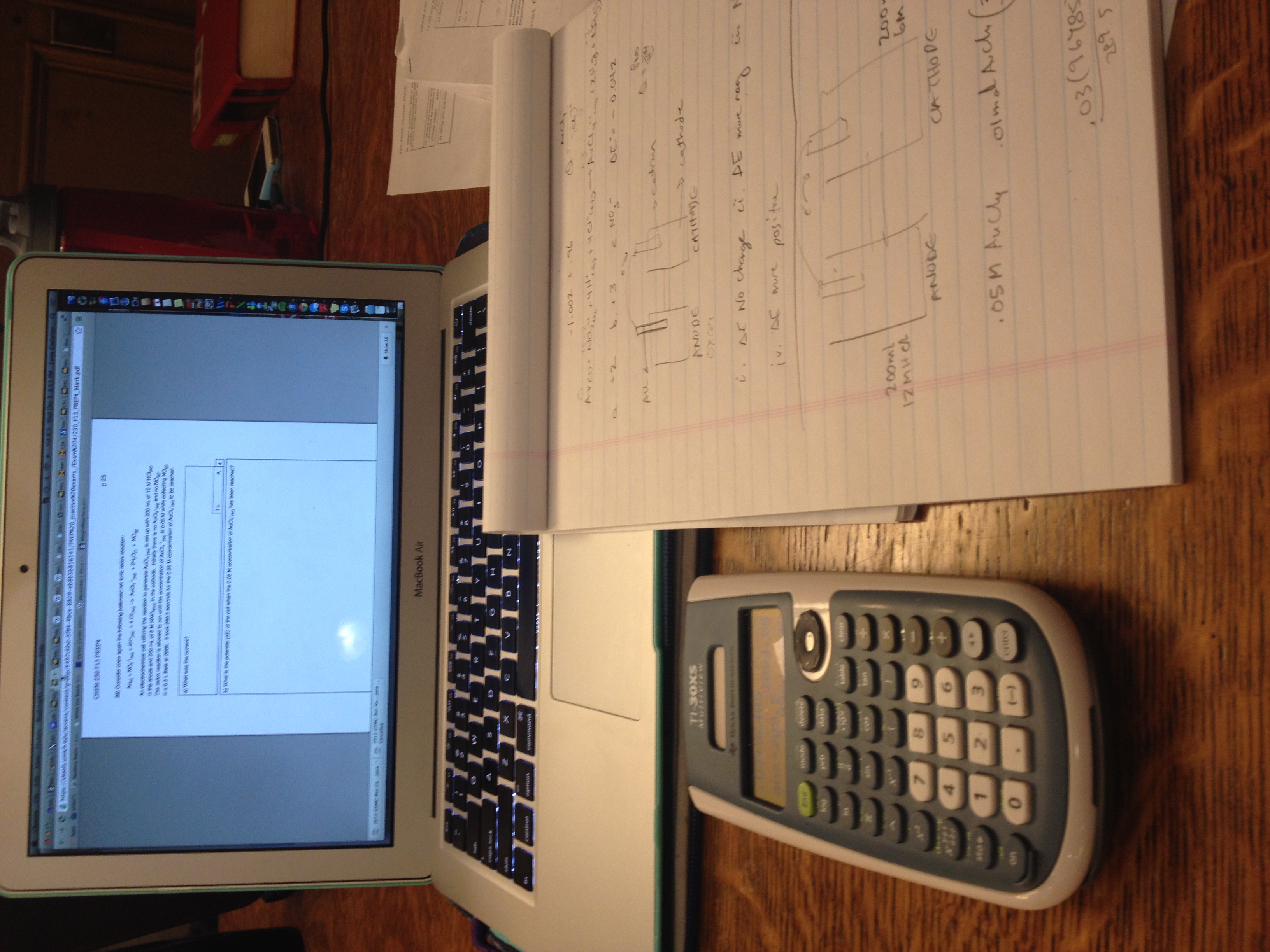 TI-30XS MultiView on a desk beside handwritten chemistry notes and a laptop.