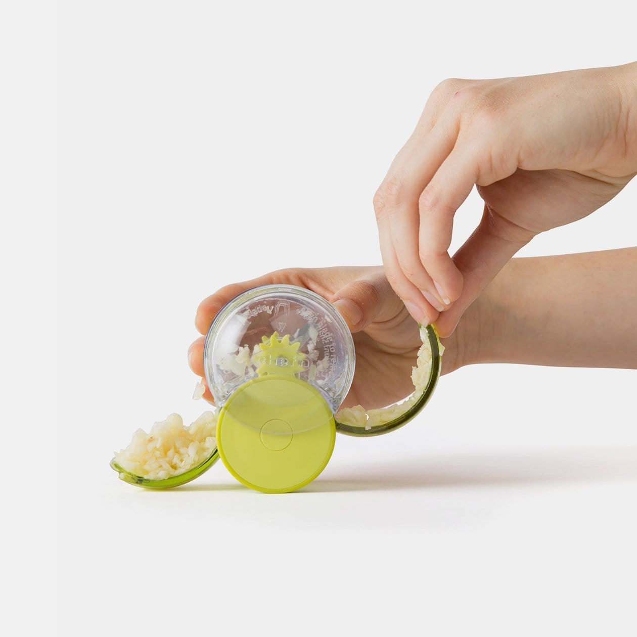 Chef'n GarlicZoom opened at both sides with the clear casing and internal parts visible